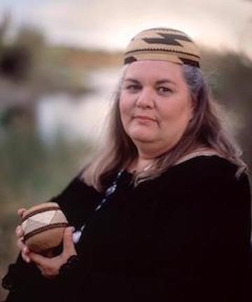 Kathy Wallace, a Native American woman holds a small basket
