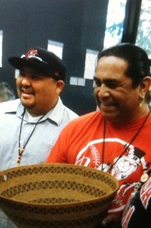 Two Santa Rosa Rancheria tribal representatives display a shallow woven basket with a round rim